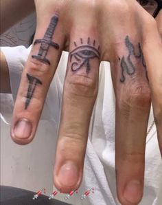 two fingers with different tattoos on them