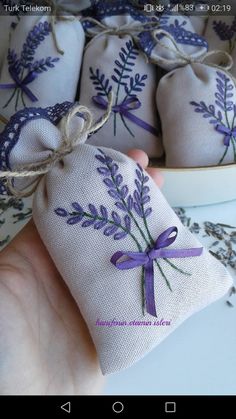 someone is holding some lavender sacs in their hand and tied with purple ribbon on them