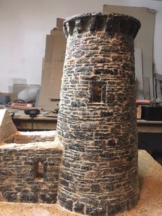 a stone tower sitting on top of a wooden table