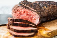 a piece of meat sitting on top of a wooden cutting board