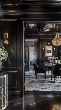 a black and gold dining room with chandelier hanging from the ceiling in front of it