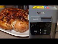 there is a chicken sitting on a plate next to a machine with the word ninja written on it