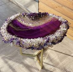 a purple chair with flowers on it sitting on top of a wooden floor