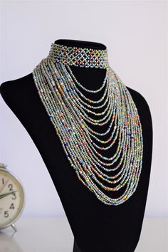 Unique African Maasai Handcrafted Beaded Necklace with an Elegant Look and Brilliant Finish. Color = Grey and Multi Color Beads. Length (Around Neck) = Adjustable Length. Length ( Downwards ) = 5.5 Inches / 14 cm. **GET FREE SHIPPING FOR ADDITIONAL ITEMS PURCHASED. Yes, Buy Multiple Items and pay shipping for 1 item only- The rest ships Free. (No Limits on the number of Multiple items). With a faster delivery time of 3 days via DHLExpress, Worldwide. Ordinary/Standard Shipping also available upo Multicolor Beaded Choker With Dangling Beads, Multicolor Beaded Chain Choker For Party, Festival Multicolor Polished Beads Choker, Party Multicolor Beaded Chain Choker, Multicolor Dangling Beads Choker, Silver Choker With Colorful Round Beads, Pokemon Jewelry, Leather Beaded Necklace, Large Bead Necklace