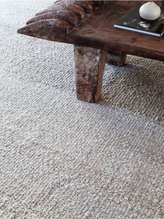 a coffee table with a book on top of it in front of a white carpet