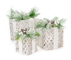 two white vases decorated with pine cones and greenery