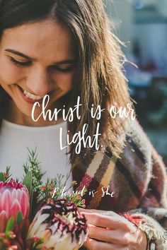 a woman holding flowers with the words christ is our light