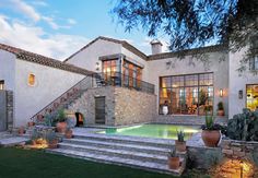 a house with a pool in the front yard and stairs leading up to it's entrance