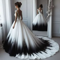 a woman in a black and white wedding dress looking into a mirror