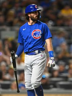 a baseball player holding a bat in his hand and wearing a helmet on top of his head