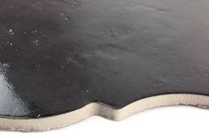 a close up view of a black surface with some white and gray spots on it