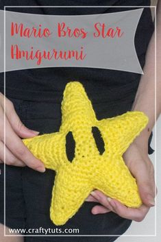 a crocheted yellow star in the shape of a smiley face is held by a woman's hands