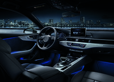 the interior of a modern car with city lights in the background