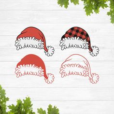 three christmas hats cut outs on top of a wooden table next to some green leaves