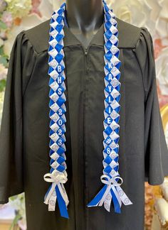 a graduation gown with blue and white ribbons hanging from it's collars on a mannequin