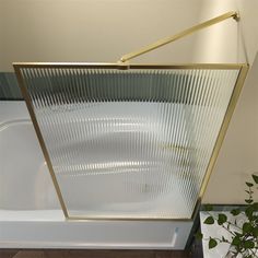 a white bath tub sitting next to a green plant