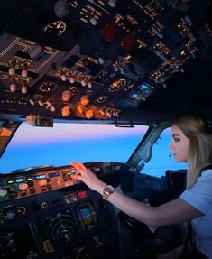 a woman is sitting in the cockpit of an airplane