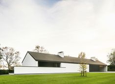 a large white house sitting on top of a lush green field