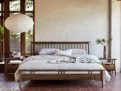 a bed sitting in a bedroom next to a window with lots of light on it