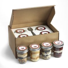 an open box with four jars filled with food