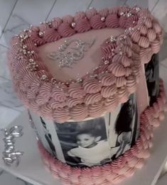 the cake is decorated with pink icing and silver decorations on it's sides