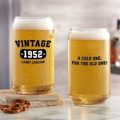 two beer glasses sitting on top of a counter