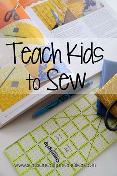 an open book sitting on top of a white table next to scissors and paper with the words teach kids to sew