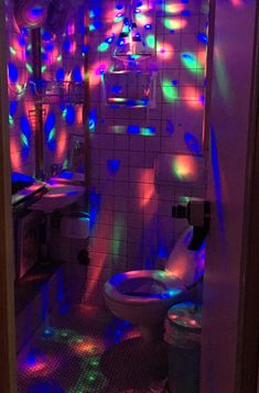 a bathroom with colorful lights on the walls