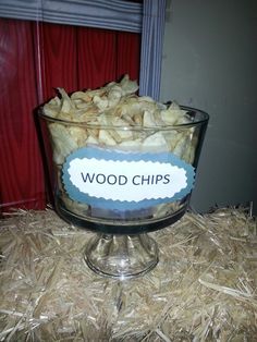 a glass bowl filled with wood chips on top of hay