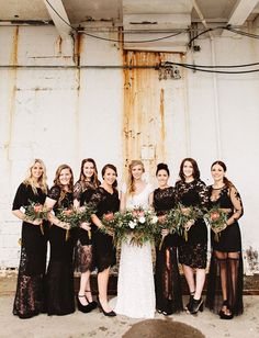 a group of women standing next to each other in front of a white wall holding bouquets