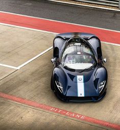 a blue sports car driving down a race track