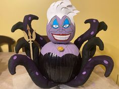 an inflatable purple and black costumed character sitting on top of a table