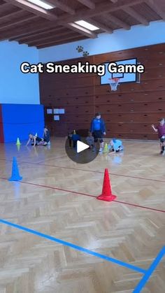 an indoor basketball court with cones and people on it