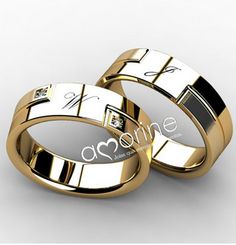 two gold wedding rings with roman numerals on each side and the word love written in