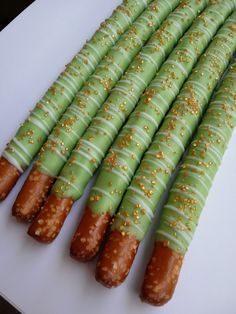 some green and gold colored food on a white plate with brown sprinkles