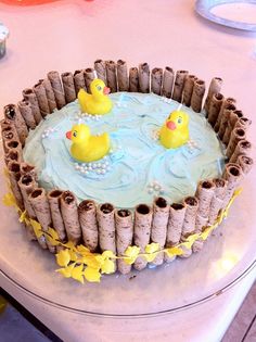 there is a cake decorated with three rubber ducks in the water