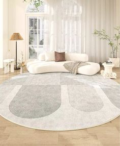 a living room with a white couch and round rug on the floor in front of a window