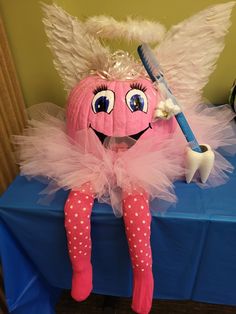 a pink pumpkin with angel wings sitting on top of a blue table