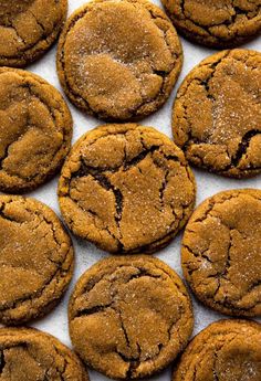 several chocolate cookies are arranged on a white surface