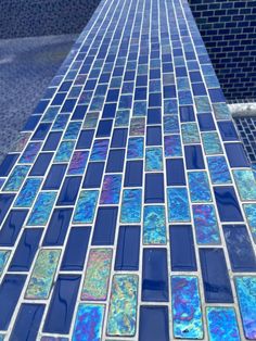 a close up view of a blue glass mosaic tile pattern on the side of a building