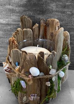 a candle holder made out of driftwood and seashells