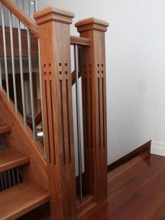 an empty room with wood floors and stairs in the center is seen from the doorway