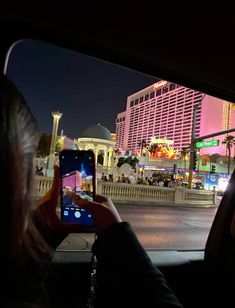 a person taking a photo in the back seat of a car with their cell phone