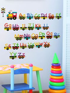 a child's playroom with toys and wall decals in the shape of trains