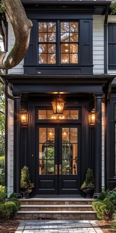 the front entrance to a house with black doors and windows