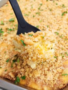 a spatula scooping some food out of a casserole dish with parsley on top