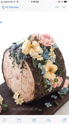 a cake with flowers on it sitting on top of a wooden table next to other items