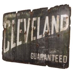 an old metal sign with the word cleveland painted on it's side and rusted edges