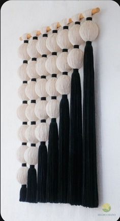 a wall hanging with black and white tassels