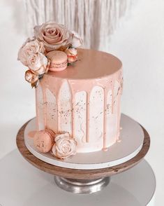 a pink cake with frosting and flowers on top